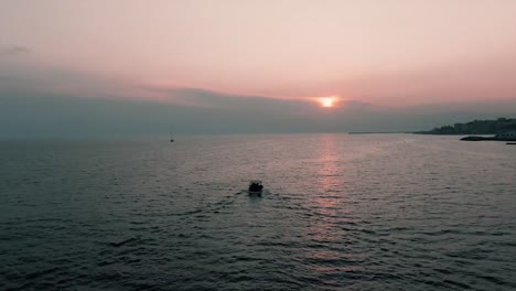 Boat-Sailing-Across-The-calm-Sea-On-A-Beautiful-Summer-Sunset-In-Italy