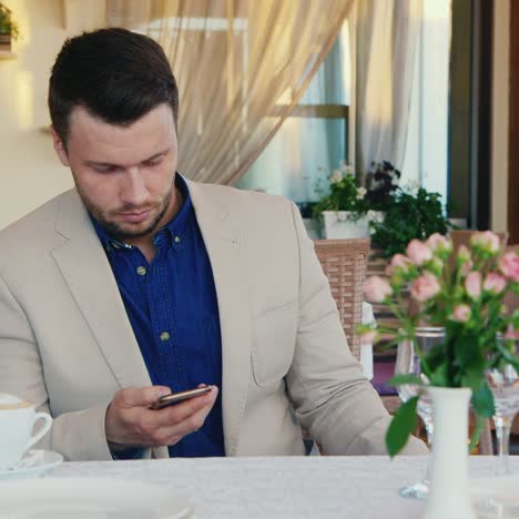 Man-Uses-Smartphone-In-A-Restaurant