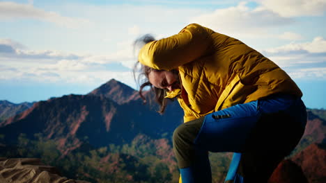 un excursionista tonto tropezando y perdiendo el equilibrio en el pico de la montaña rocosa