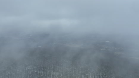 Drone-Vuela-A-Través-De-La-Niebla-Sobre-La-Cima-De-Una-Montaña-Cubierta-De-Nubes