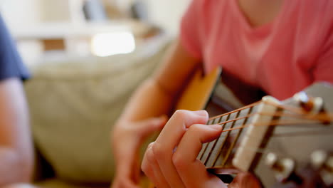 girl playing guitar in living room 4k