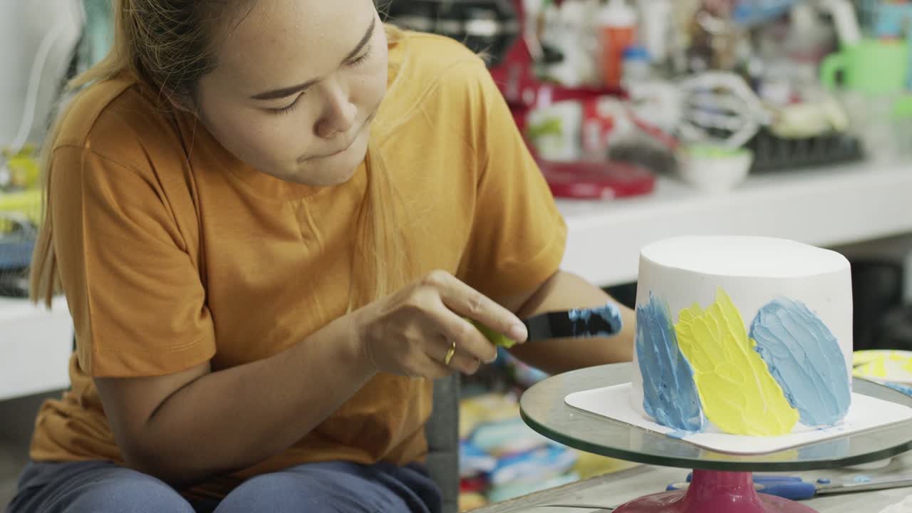 el chef está decorando la crema alrededor del pastel.