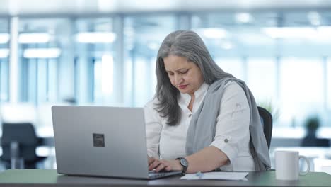 directora india senior que trabaja en una computadora portátil