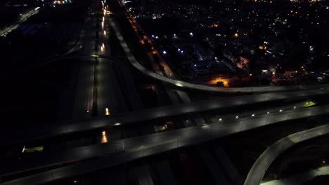 Vista-Aérea-Nocturna-De-La-Autopista-Y-El-Intercambio-Con-Edificios-Al-Costado---Una-Toma-Aérea-Del-Intercambio-Peshawar-Morr-Islamabad---Vista-Aérea-Nocturna-De-Islamabad-Pakistán