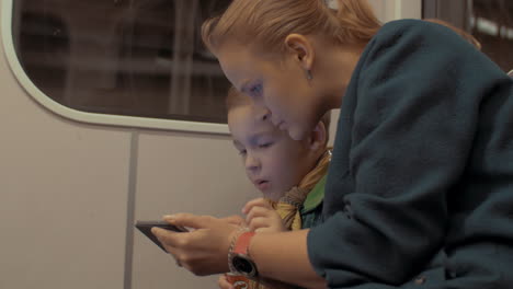 Foto-De-Madre-E-Hijo-Viajando-En-El-Metro-Usando-Un-Teléfono-Inteligente-Durante-El-Viaje-A-Praga,-República-Checa