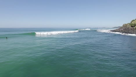 Surfers-At-The-Beach-In-The-Famous-Burleigh-Heads-In-Queensland,-Australia---aerial-drone-shot