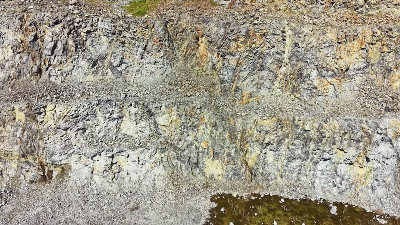Granitbrud der viser lag af klippe og sten nær en vandkilde om dagen på et landligt sted med klar sigtbarhed