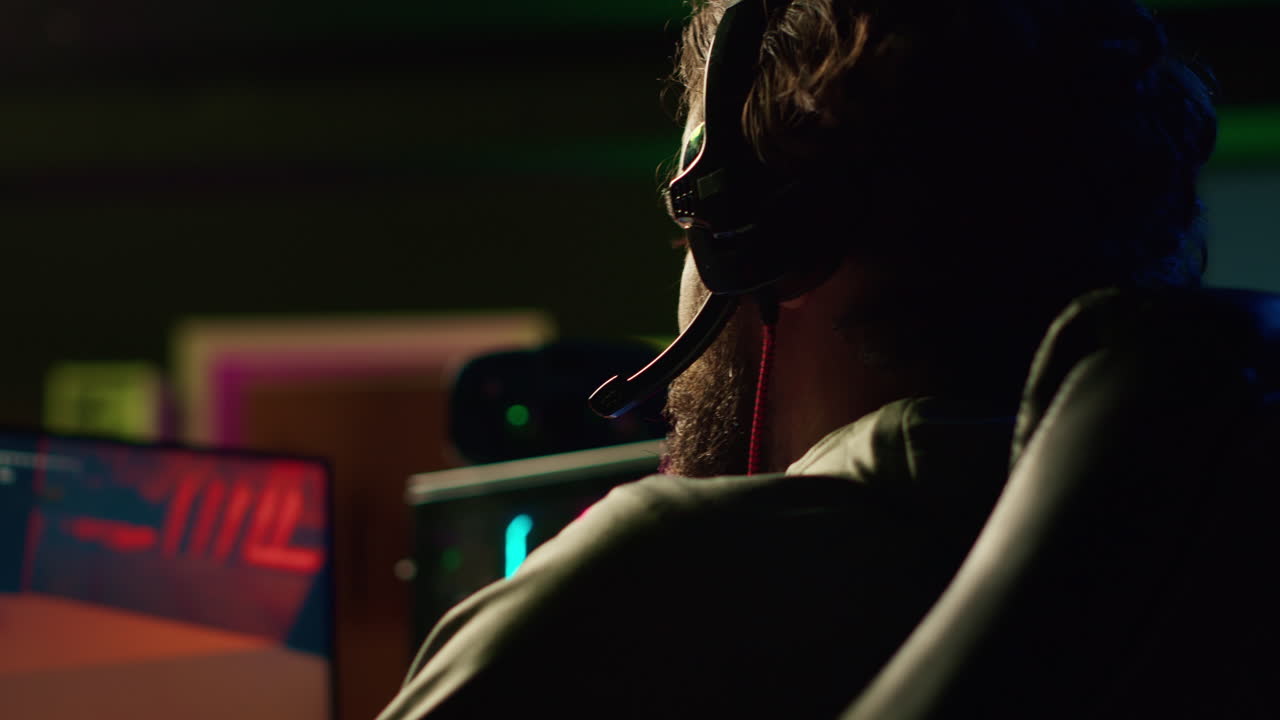 Man playing science fiction FPS videogame with friends, chatting through headphones mic, close up