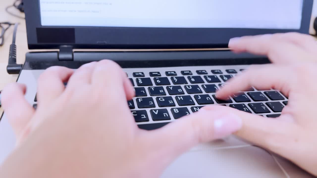 Front perspective of hands performing data entry on a laptop keyboard.