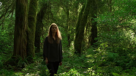 a woman meditating in a lush green forest