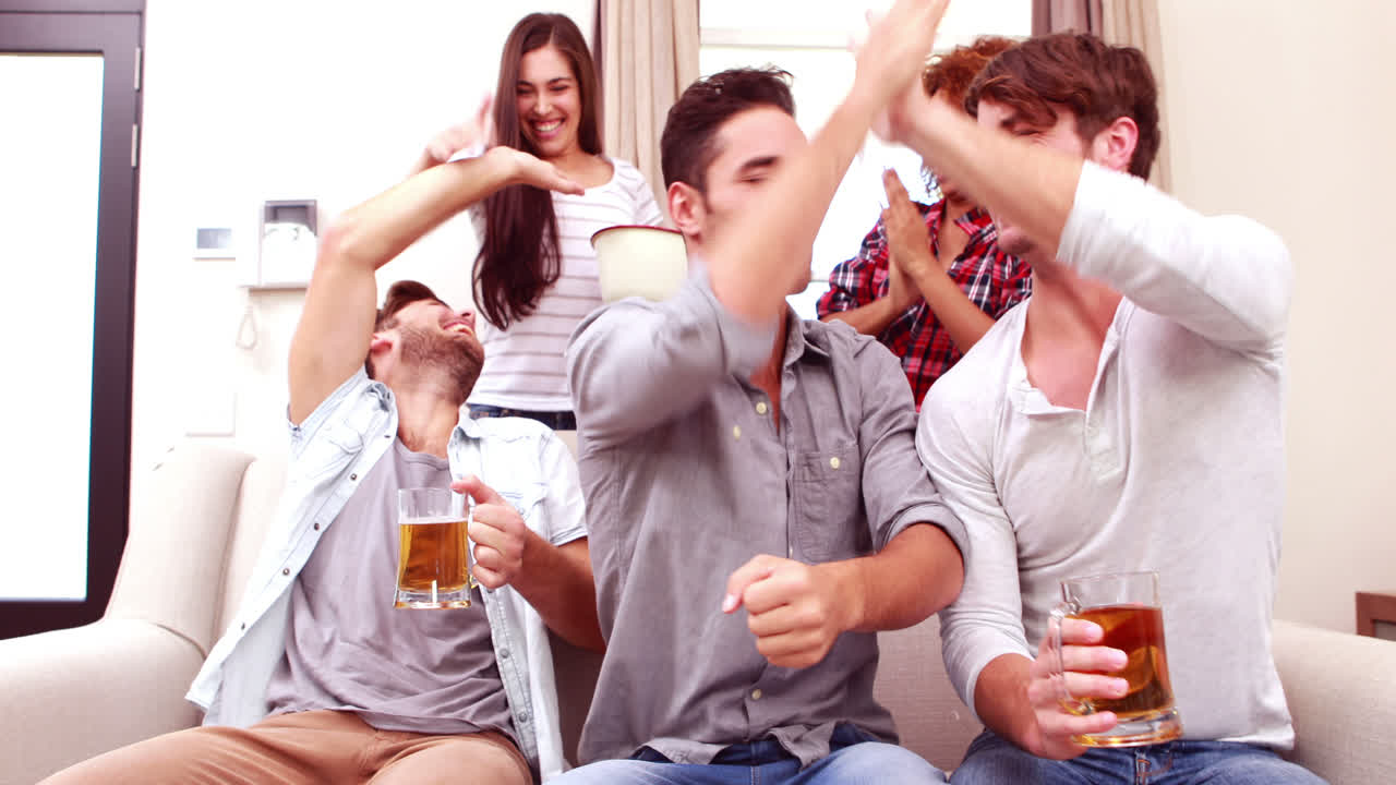 친구 들 이 tv 에서 스포츠 를 보고 맥주 를 마시는 것