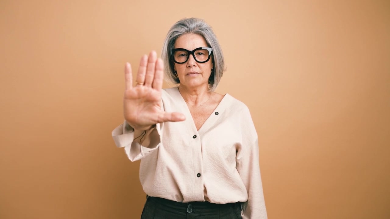 Mujer madura haciendo un gesto de alto con la mano