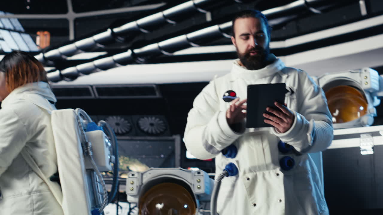 Astronaut reading mission plan on tablet before stepping out of space station