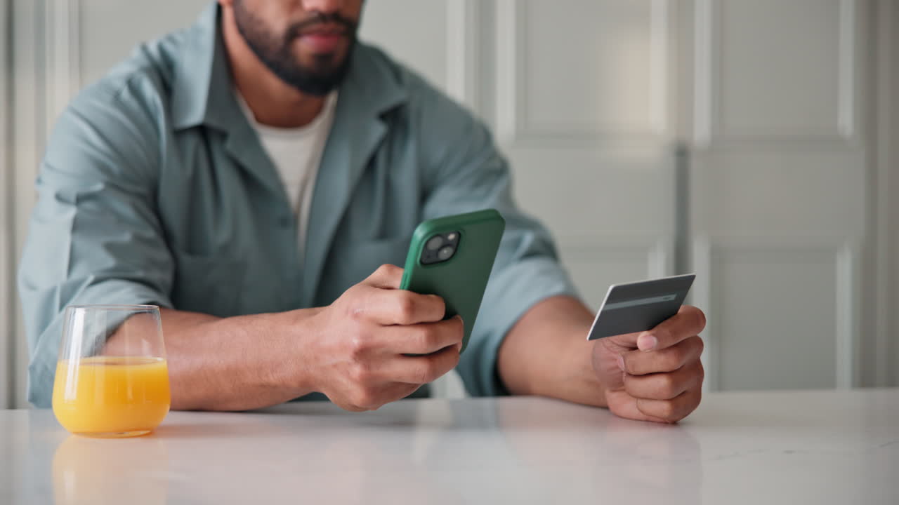 Persona che utilizza una carta di credito e uno smartphone per fare acquisti online