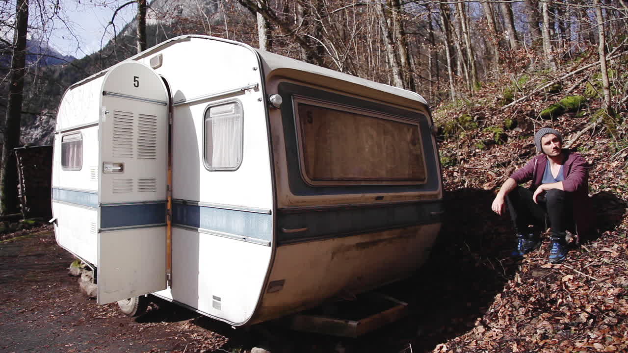그의 밴 밖에서 일광욕을 즐기는 백인 남자