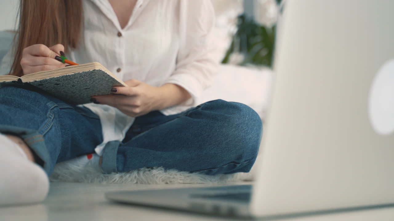 아주 귀여운 젊은 여성이 집에서 요가를 하고 그녀의 개가 그녀 주위를 계속 돌고 있습니다.