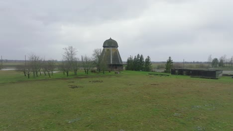 beautiful aerial establishing view of old wooden windmill in the middle of the field, prenclavu windmill , overcast winter day, wide ascending drone point of interest shot