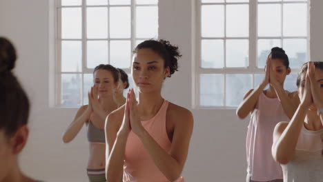 Clase-De-Yoga-Mujer-Sana-De-Raza-Mixta-Practicando-Pose-De-Oración-Con-Un-Grupo-De-Mujeres-Hermosas-Disfrutando-De-Un-Estilo-De-Vida-Saludable-Haciendo-Ejercicio-En-El-Gimnasio-Al-Amanecer