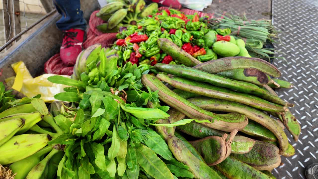 Stacked tropical fruits arranged on the floor in a vibrant Venezuelan street food market