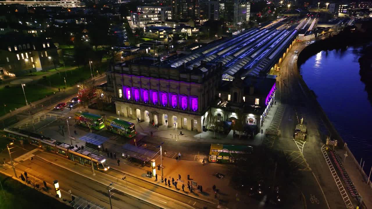 4K cinematic drone footage of Heuston Station in Dublin at sunset, highlighting the historic building, approaching trains, and the Dublin skyline under dramatic sunset hues. Dublin_033