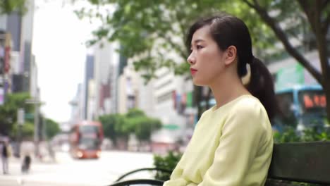 woman sitting alone on a bench in the city