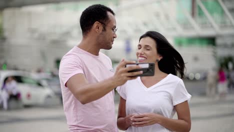 una joven pareja alegre grabando un mensaje de video