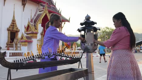 women praying at a temple in thailand