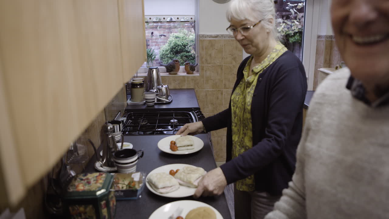 Coppia anziana che prepara dei panini in cucina