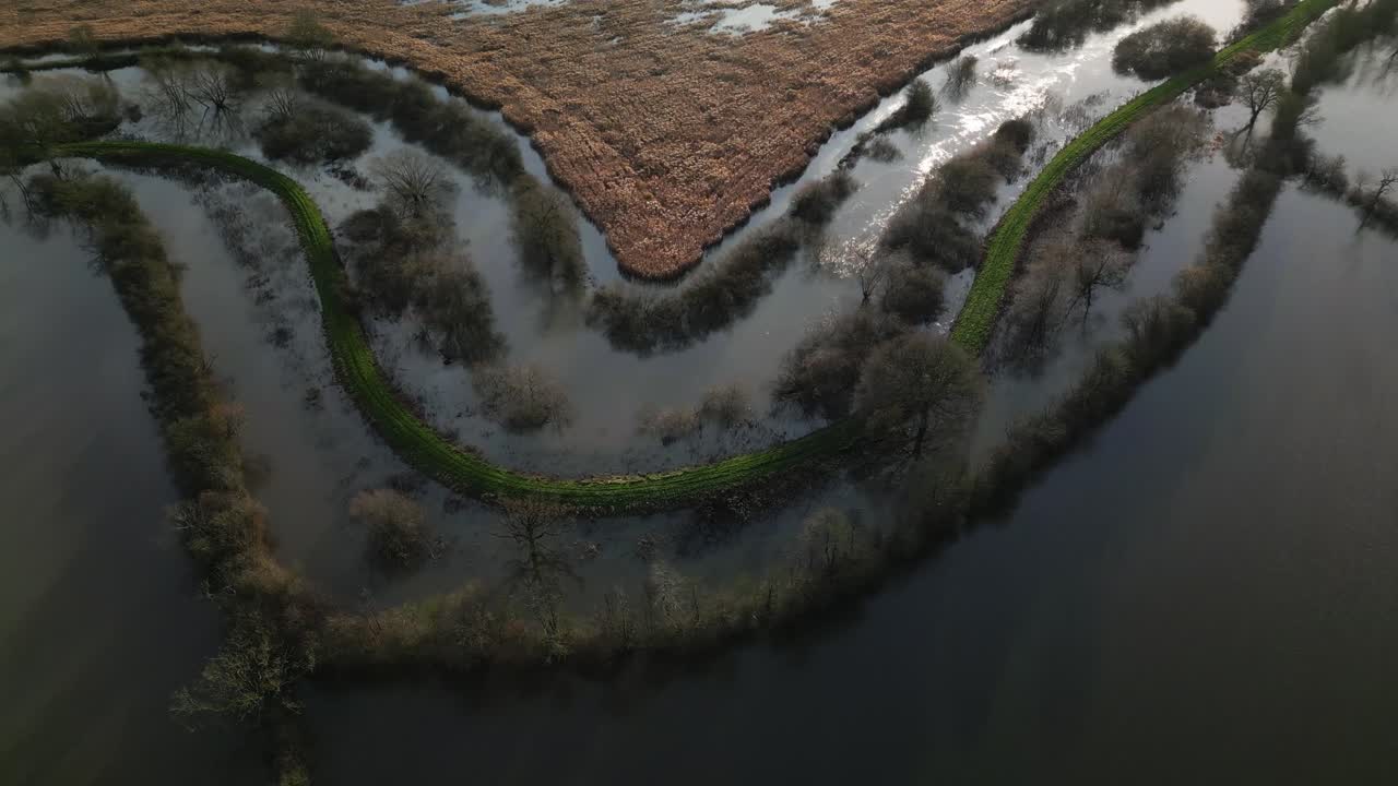 Letecký pohled z dronu na klikatící se rozvodněnou řeku Derwent nad zatopenými poli, obchvat Malton A64, klidná nálada