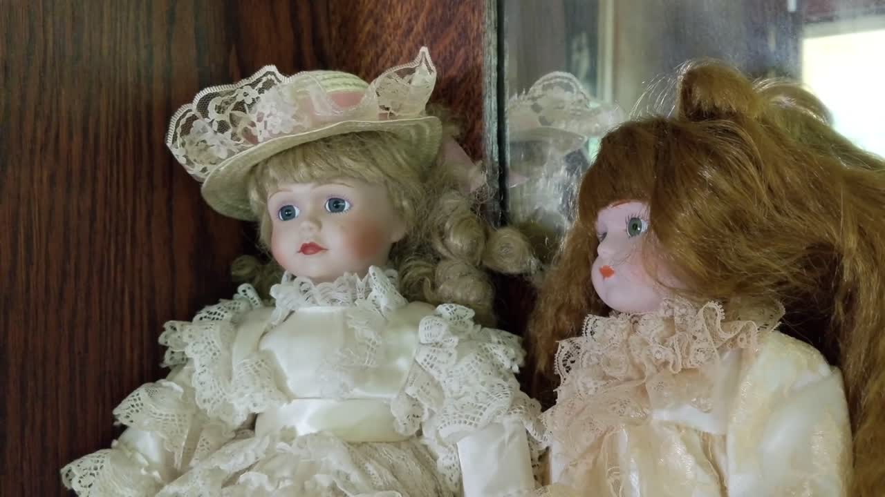 Poupées anciennes de filles assises et regardant fixement, rousse, blonde, d'apparence inquiétante