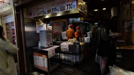 person interacts with vendor at busy food stand