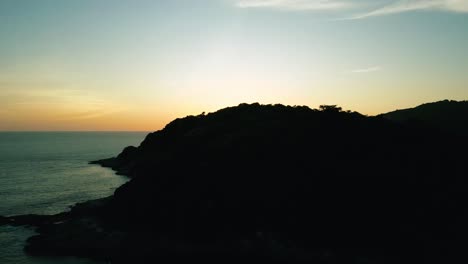 4k cinematic nature aerial footage of a drone flying over the beautiful beaches of promthep cape in phuket, thailand during sunset