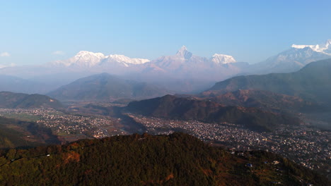 establishing drone shot of pokhara and snowy himalayan peaks, sunrise in nepal