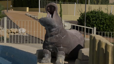 hippo statue next to a swimming pool