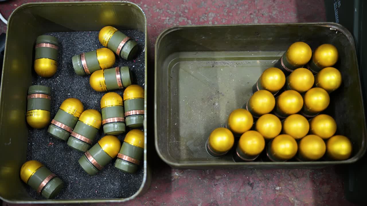 At a Donetsk region drone workshop in Ukraine, grenades are modified with plastic casings for drone attachment. Showcasing adaptive weapon production for modern warfare.