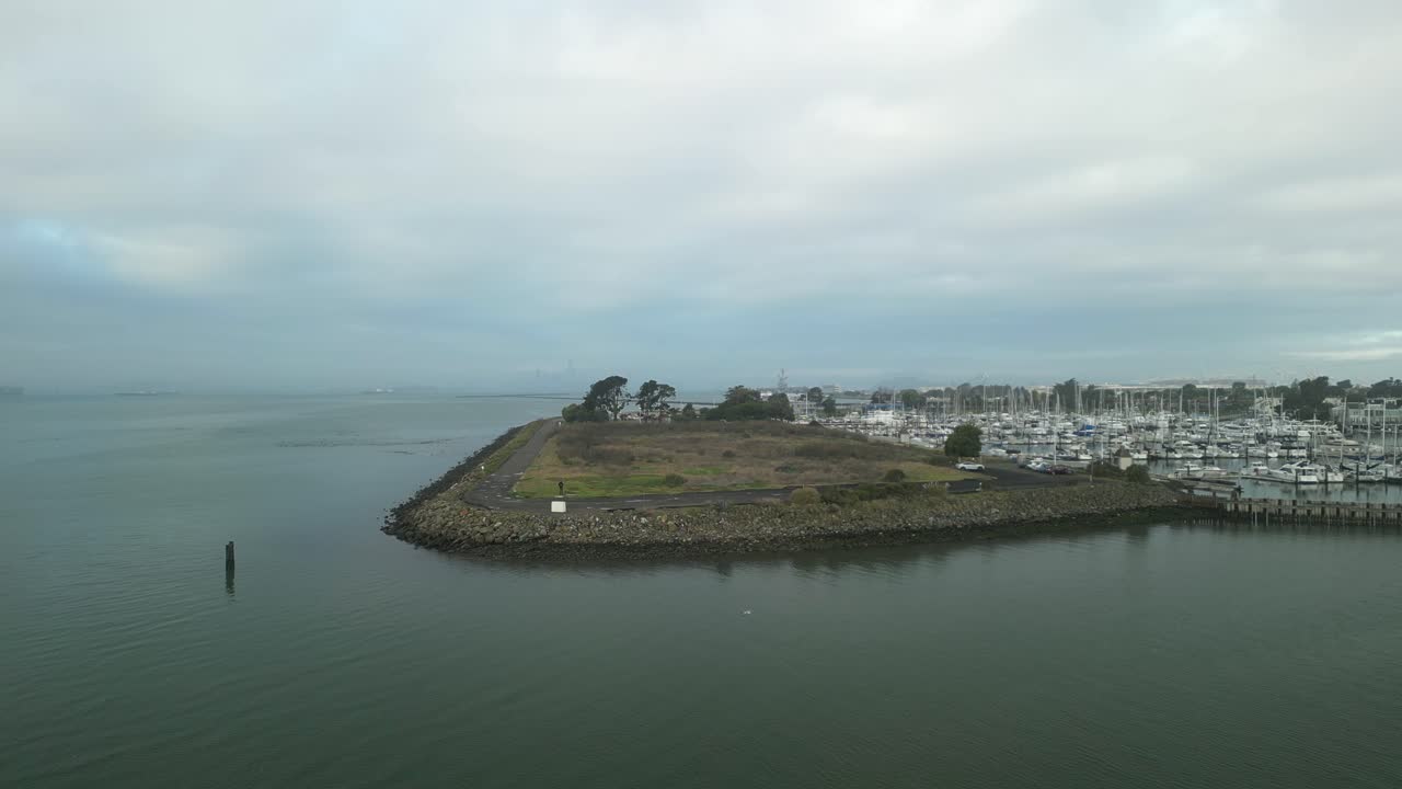 una escena aérea estática de crab cove en alameda, california, haciendo hincapié en sus aguas tranquilas, espacios abiertos y cielo matinal.