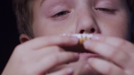 Little-boy-devouring-frosted-cookie,-Eating-Timelapse-Close-Up-on-Face