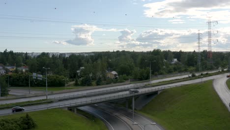 aerial pan out of cars driving on a motorway bridge in finland near helsinki