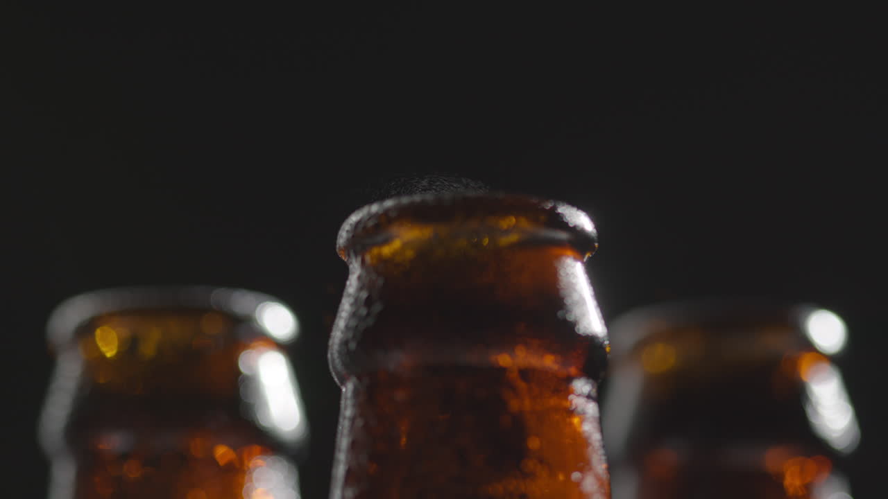 Close Up Of Condensation Droplets On Neck Of Bottles Of Cold Beer Or Soft Drinks With Water Vapour After Opening