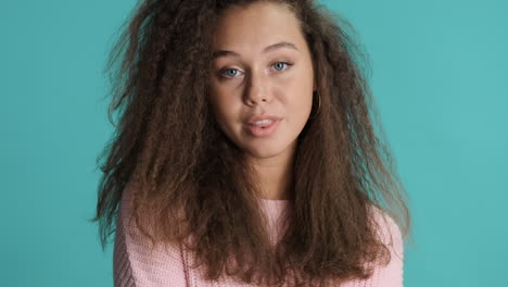 Caucasian-curly-haired-woman-smiling-to-the-camera.