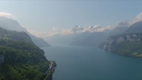 morschach flyover: moving over scenic water valley towards alps mountains, switzerland, europe, drone | inland movement along hillside to vast majestic blue lake