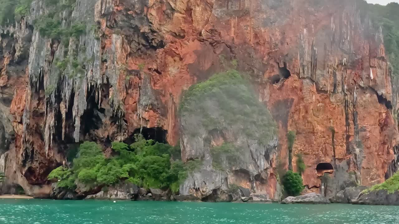 Explore the vibrant limestone cliffs adorned with lush greenery against a serene turquoise sea.