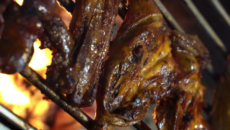 chicken inasal - brushing sauce on chicken over fire on griller