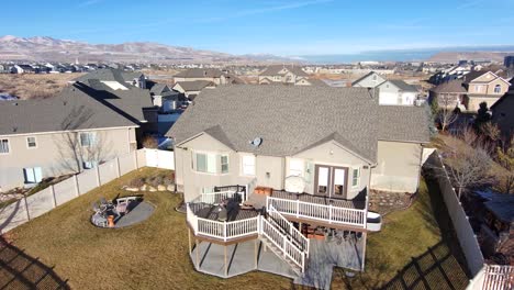 a senior man drinks coffee on his backyard deck the ascend to see the home and neighborhood from a high altitude looking down