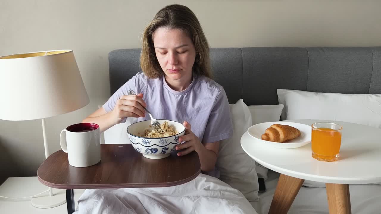 침대에서 아침을 먹는 여자