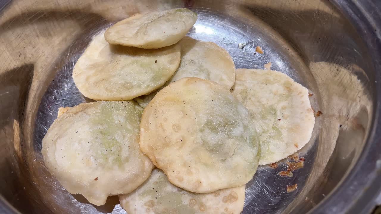 Kolkata style kachoris in steel tray to be served to guests in wedding.