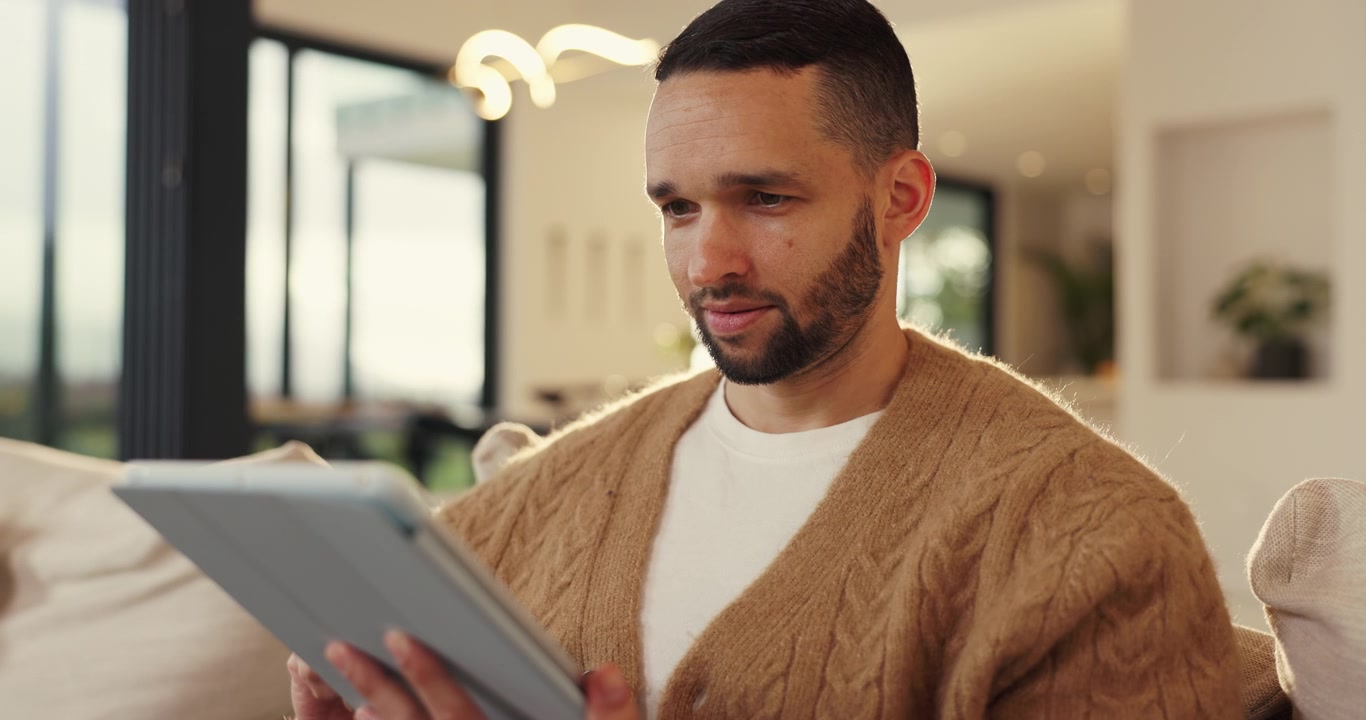 Man Using Tablet While Relaxing on Sofa at Home