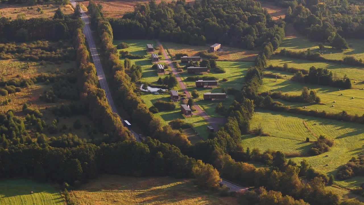 Small village and green landscape during golden hour, aerial view