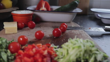 tomatoes being dropped onto wooden chopping board