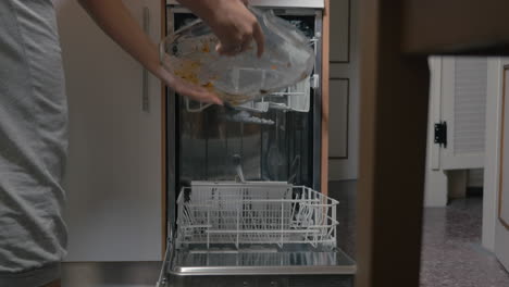 putting dirty dishes into dishwasher